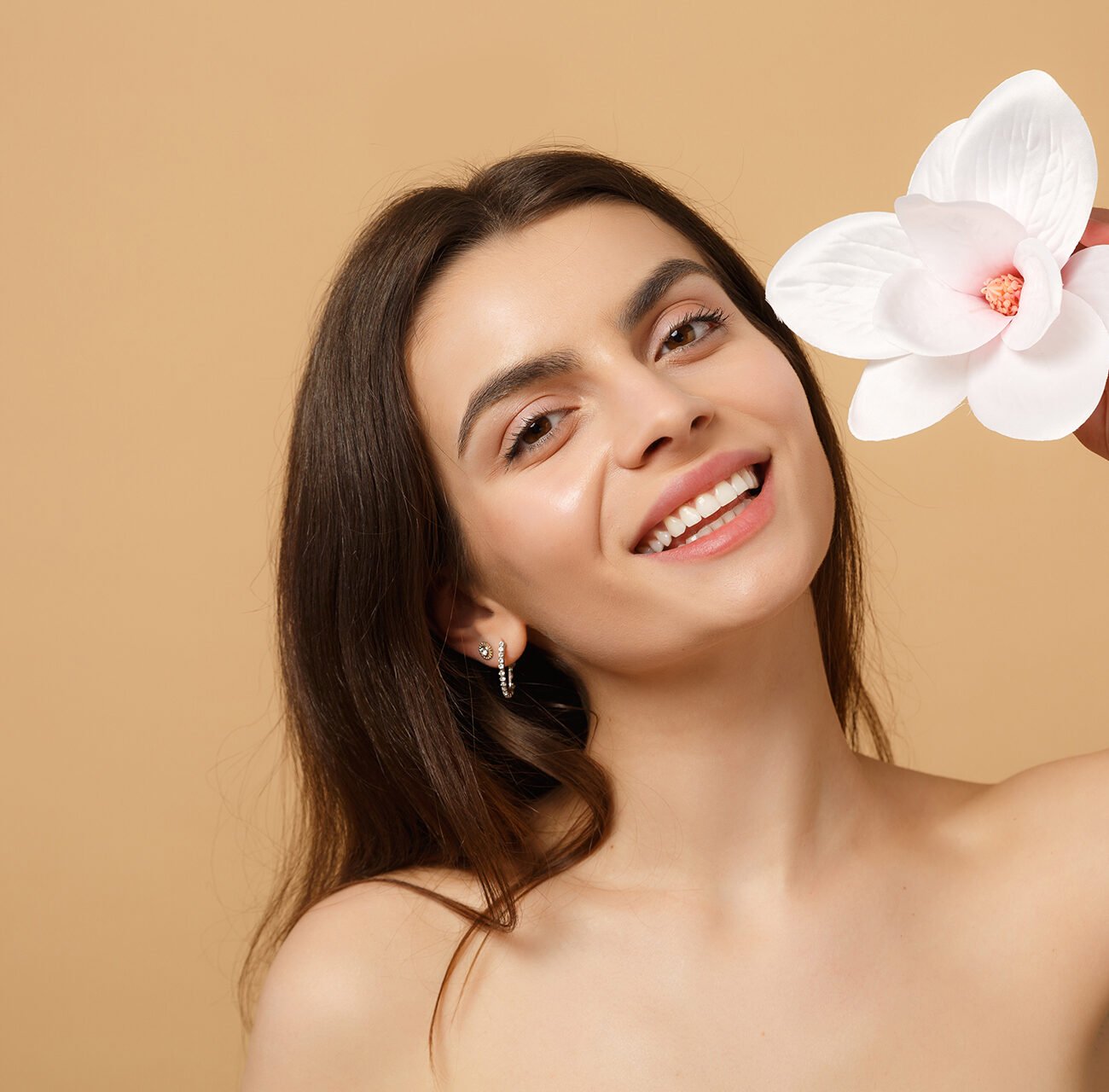 Close up brunette half naked woman 20s with perfect skin, nude make up isolated on beige pastel wall background, studio portrait. Skin care healthcare cosmetic procedures concept. Mock up copy space.