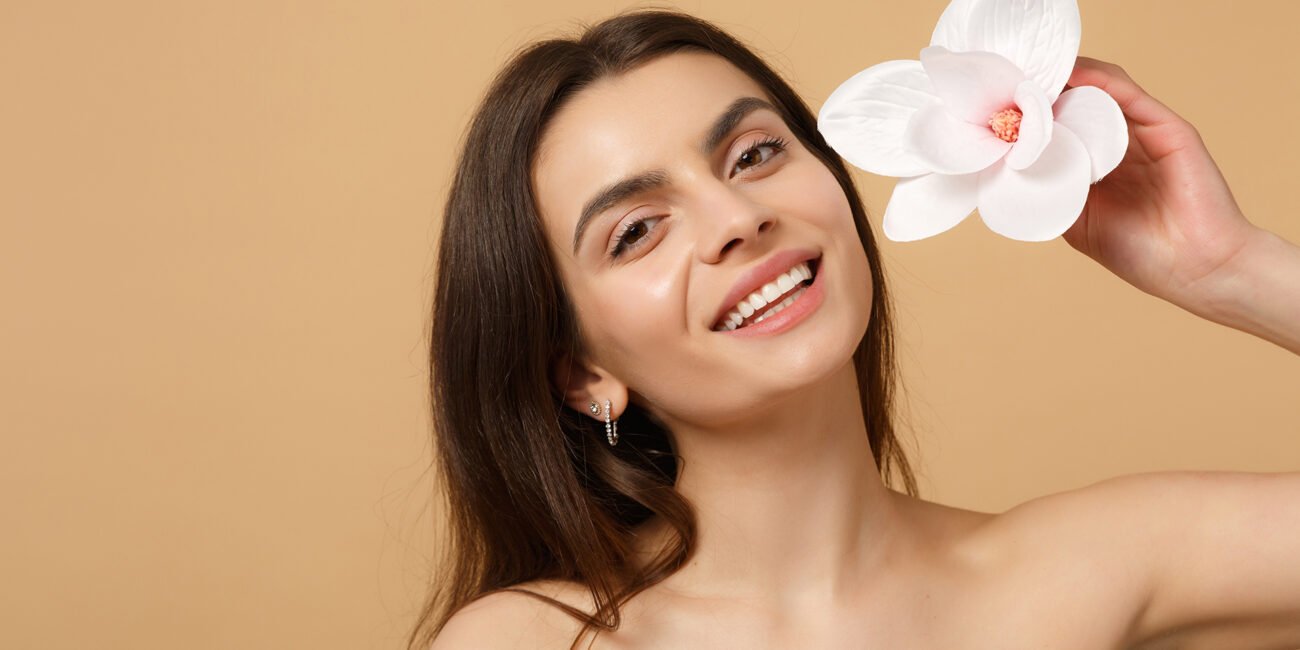 Close up brunette half naked woman 20s with perfect skin, nude make up isolated on beige pastel wall background, studio portrait. Skin care healthcare cosmetic procedures concept. Mock up copy space.